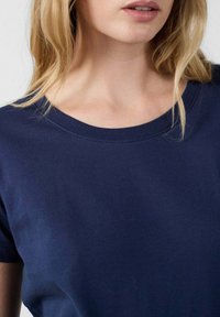 T-shirt in cotone blu navy con scollatura rotonda e maniche corte, caratterizzato da una texture liscia e dettagli di cucitura minimi.