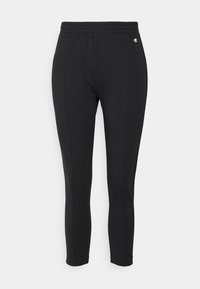 Schwarze Sportleggings mit einem elastischen Bund, dehnbarem Stoff, tailliertem Design und einem kleinen Logo-Detail an der Seite.