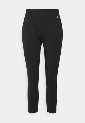 Black athletic leggings with an elastic waistband, stretchy fabric, fitted design, and a small logo detail on the side.