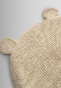 Svetlobéžová pletená čiapka s rebrovanou textúrou a zaoblenými uškami na vrchu. Tkanina vykazuje jemné farebné odtiene.