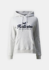 Felpa grigia con cappuccio, tasca frontale, stringhe bianche e logo "Hollister California" blu navy sul petto. Materiale morbido in misto cotone.