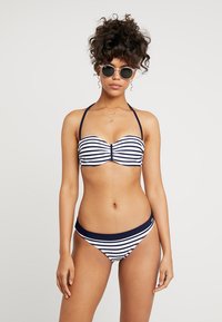 Stripet bikini i marineblått og hvitt; bandeau topp med samlet detalj og justerbare stropper; lavt midje undertøy med matchende striper.