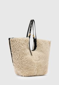 Tote bag met een zachte crèmekleurige wollen buitenkant en gladde zwarte leren accenten. Voorzien van verstelbare zwarte banden en een ruim ontwerp.