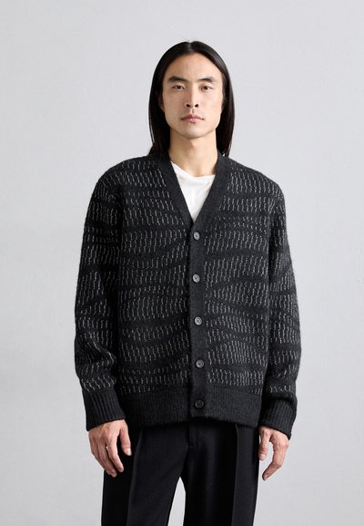 Schwarze Strickjacke mit strukturiertem Streifenmuster, V-Ausschnitt und fünf Knopfverschlüssen, sowie gerippten Bündchen und Saum.