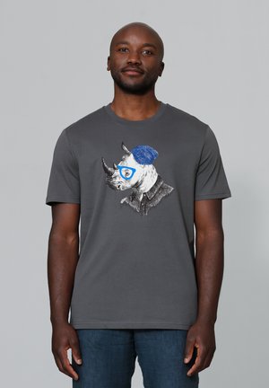 Grijze katoenen t-shirt met een grafisch ontwerp van een neushoorn die een blauwe hoed en bril draagt, met een mix van zwart, wit en blauwe kunst.