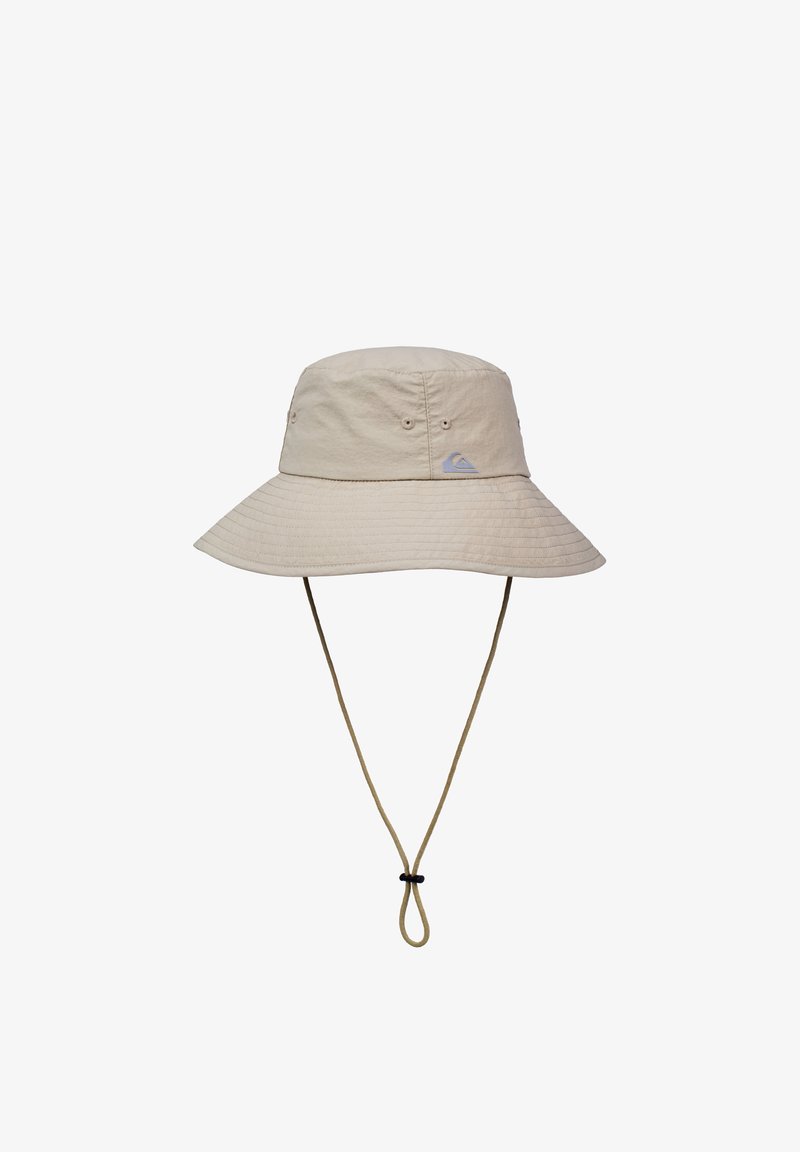 Μπεζ καπέλο τύπου bucket με φαρδύ γείσο, κατασκευασμένο από ελαφρύ ύφασμα. Διαθέτει ρυθμιζόμενο λουράκι στο πηγούνι και μικρό λογότυπο της μάρκας στην πρόσοψη.