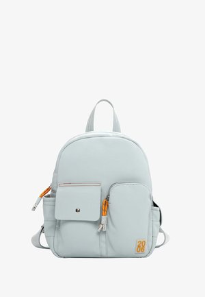 Sac à dos gris clair avec deux poches avant, des accents de fermeture éclair orange et des sangles réglables. Fabriqué en matériau lisse avec une forme ronde.