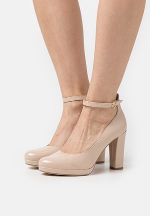 escarpins à talons hauts en cuir verni nude avec une bride à la cheville et un bout rond. Dotés d'un talon épais et d'une finition lisse et brillante.