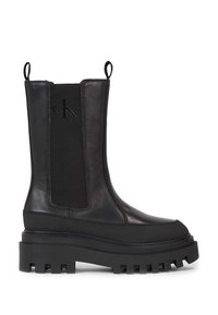 Zwarte enkelboots met een combinatie van leer en elastische panelen, een platte chunky zool met ingekerfde details en accentuerende aantreklussen.