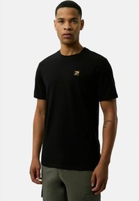 Czarny bawełniany t-shirt z krótkimi rękawami i okrągłym dekoltem. Posiada małą złotą naszywkę z logo w lewej części klatki piersiowej.