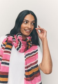 Sciarpa leggera con motivo a strisce rosa, arancioni e nere. Il tessuto ha una finitura strutturata e si drappeggia morbido intorno al collo.