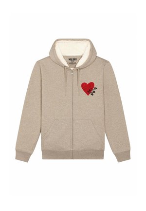 Beige ritsluiting hoodie met een zachte, pluche binnenkant. Voorzien van een rood hartontwerp met zwarte veiligheidsspelden. Inclusief frontzakken en geribbelde manchetten.