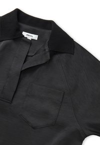 Polo nero con colletto a maglia testurizzata, maniche corte e taschino. Realizzato in tessuto liscio con un leggero luccichio.