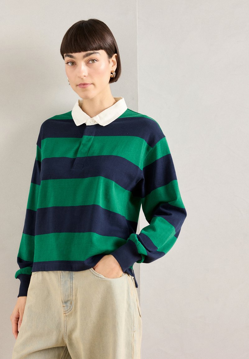 Poloshirt met lange mouwen, voorzien van groene en marineblauwe horizontale strepen, een witte kraag en een knoopsluiting, gemaakt van een zachte stof.