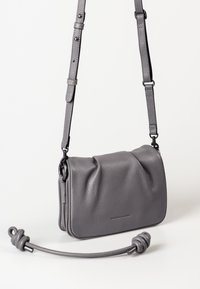 Graue Leder-Crossbody-Tasche mit strukturiertem Oberflächenmaterial, verstellbarem Tragegurt und einem geknoteten Griffdetail. Kompakte rechteckige Form.