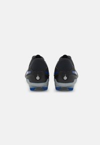 Chaussures de sport noires avec une texture lisse, un design moulé et des accents bleus sur les côtés et les semelles. L'arrière présente un logo distinctif.