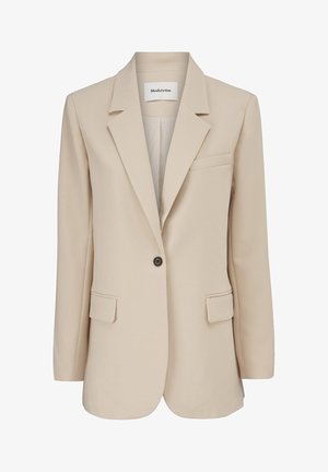 Blazer beige à un bouton avec revers crantés, deux poches à rabat, une poche poitrine à fente, et une étiquette Modström à l'intérieur du col.