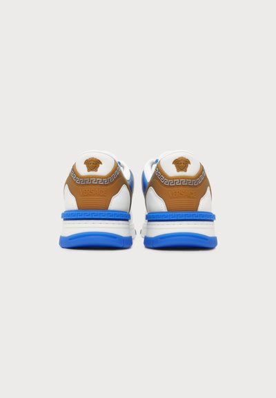 Ζευγάρι λευκά, μπλε και καφέ sneakers Versace, εμφανιζόμενα από πίσω, με το λογότυπο Medusa και σχέδια στη φτέρνα.