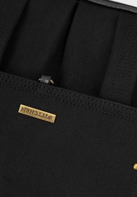 Bolsa de tela negra con herrajes dorados, con una superficie texturizada y detalles de costura. Incluye una etiqueta de marca embellecida con "Wittchen."
