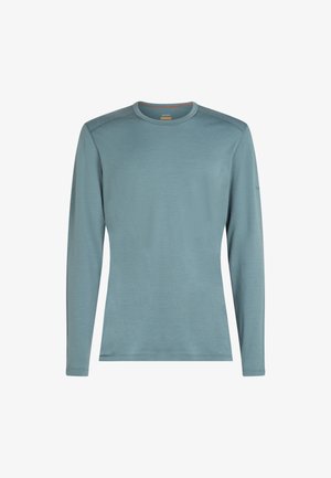 Long-sleeve shirt in soft light blue fabric with a round neck, flat seams, and a minimalist design, featuring no visible patterns or graphics.