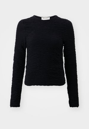 Black long-sleeve top made of textured material with a crinkled design, featuring a crew neck and a hem that sits at the waist.