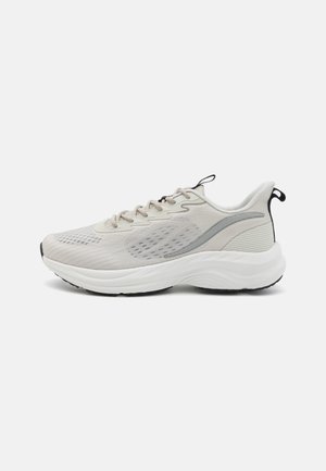 Adidaș gri deschis cu un superior din plasă texturată, accente reflective, o talpă intermediară amortizată și o talpă exterioară neagră.