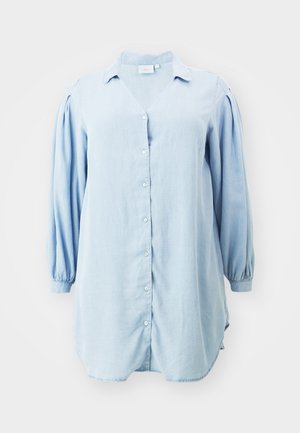 Camicia azzurro chiaro in un tessuto leggero, con scollo a V, maniche lunghe a sbuffo e orlo curvo. Design semplice e pulito.