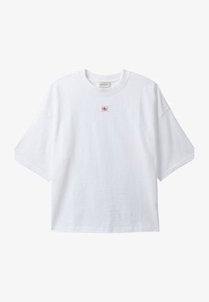 White short-sleeve t-shirt with a crew neck and a small red and black "ck" logo patch centered below the neckline.