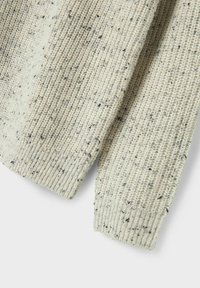 Hellbeige gestrickter Pullover mit einem strukturierten Muster und dunkleren gesprenkelten Akzenten. Verfügt über gerippte Bündchen und eine lockere Passform.