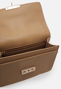 Borsa a mano in pelle marrone con texture, dotata di hardware dorato, con chiusura a patta e tasca con zip interna. Design strutturato con linee pulite.