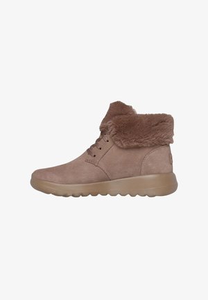 Botas de tobillo de ante marrón con un collar de pelo sintético, suela de goma y diseño con cordones. Presentan una puntera redondeada y una textura suave.