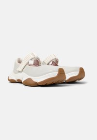 Scarpe sportive con tomaia grigio chiaro, fasce elastiche e suola in gomma texturizzata marrone. Forma arrotondata con design imbottito per il comfort.