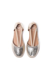 Chaussures slip-on en argent métallisé avec des sangles élastiques. Tige en toile, bout rond et semelle en jute. Texture lisse avec des détails cousus.