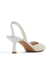 Bílé slingback podpatky s texturovaným povrchem, perlovými akcenty, špičatou špičkou a zúženým designem podpatku.