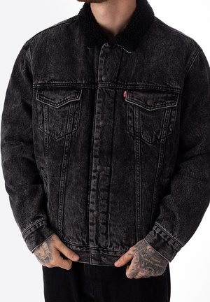 Zwarte denim jacket met een gestructureerde sherpa-kraag, voorzien van voorzakken, knoopsluitingen en een vervaagde wassing voor een versleten uitstraling.