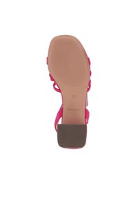 Sandalia de tacón alto fucsia con suela texturizada, correas ajustables y tacón cuadrado. Logotipo de la marca visible en la suela, tamaño 37.