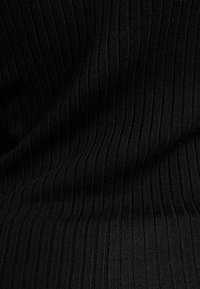 Tissu noir côtelé avec une texture fine, présentant des lignes verticales et une finition lisse, adapté aux vêtements décontractés ou formels.