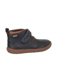 Zapato de tobillo en negro y marrón para niño, con tira de Velcro y suela marrón texturizada, diseñado para la comodidad y fácil ajuste.