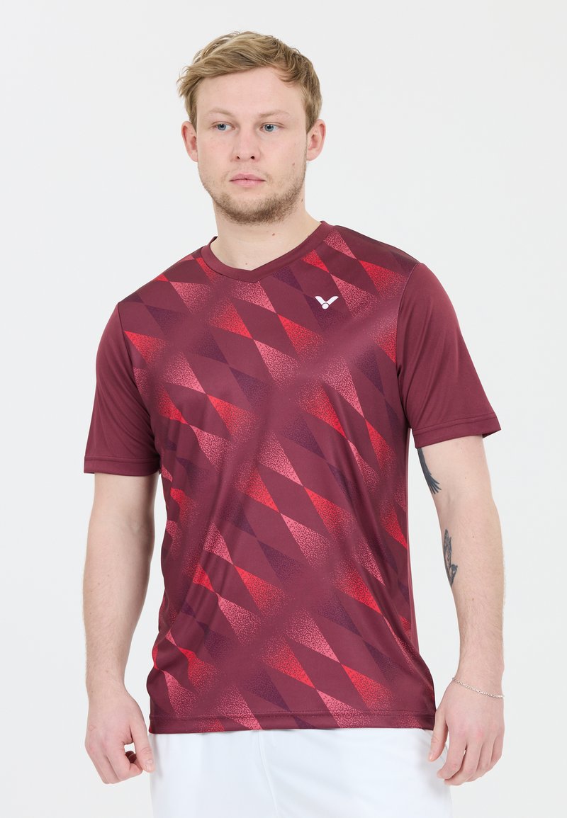 Burgundy lyhythihainen urheilupaita, jossa on eri sävyissä oleva timanttikuvio, sileä rakenne ja V-pääntie, jossa on pieni logo.