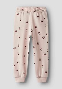 Jasnoróżowe spodnie dresowe dla dzieci z elastycznym pasem i wzorem w czerwone i zielone wiśnie rozrzucone na całej powierzchni.