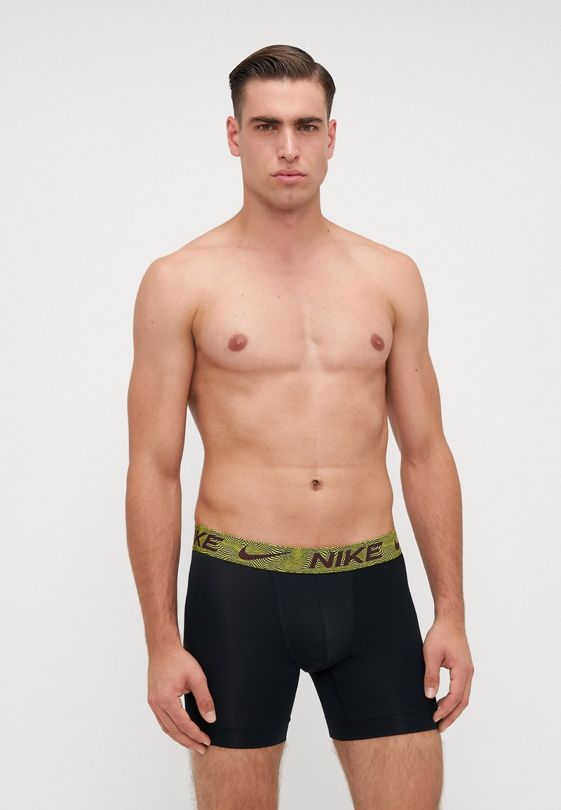 Fekete boxer alsónadrág zöld mintás elasztikus derékkal, rajta a "NIKE" felirattal. Simább anyag, testhezálló fazon, combközép hosszúság.