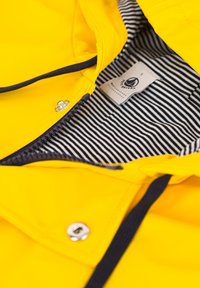 Veste de pluie jaune vif avec un doublure intérieure rayée, fermeture éclair et boutons-pression avec des accents marins.