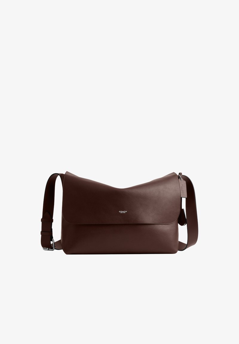 Sac messager en cuir brun foncé avec bandoulière réglable et rabat à fermeture, petit logo argenté Coach centré sur le rabat avant.