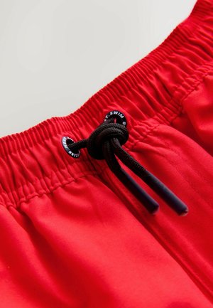 Rode zwemshorts met een elastische tailleband, zwarte trekkoord en gebrande oogjes. Gladde textuur met een eenvoudig ontwerp.