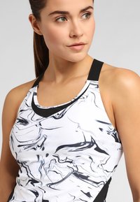 White athletic tank top featuring a marble pattern in black, with a solid black strap at the neckline and a fitted design.