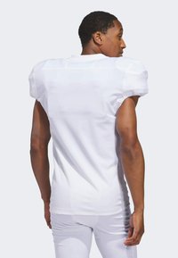 Camiseta de fútbol de manga corta blanca con hombros acolchados, textura suave y diseño entallado. Presenta un escote redondo y costuras mínimas.