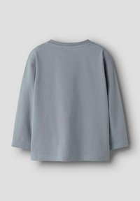 Világosszürke, hosszúujjú crewneck póló, sima hátsó résszel és egyenes aljjal, világosszürke háttéren kiemelve.