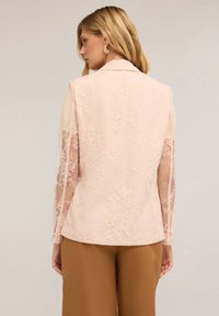 Blush-pink Jacke mit floralen Spitzenapplikationen und transparenten langen Ärmeln, ausgestattet mit einem klassischen Kragen und glatter Stoffoberfläche.