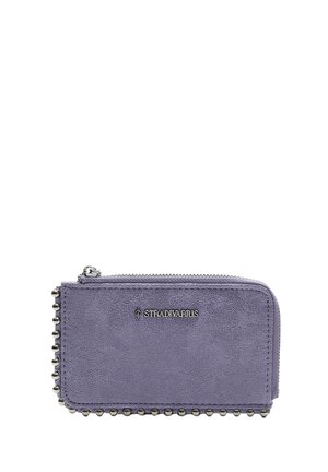 Portefeuille en cuir violet avec fermeture éclair, présentant un bord clouté et un logo métallique. Texture lisse et forme rectangulaire.