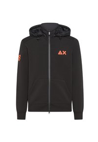 Felpa nera con zip e cappuccio foderato, dettagli arancioni, due tasche frontali e logo sul petto. Realizzata in tessuto morbido e textured.